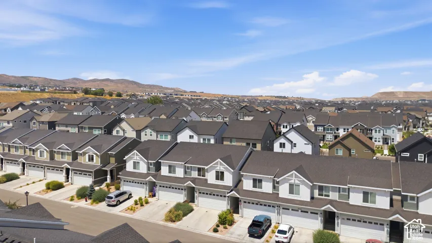 Residential neighborhood featuring contemporary homes with attached garages, dark shingle roofs, and light-toned siding