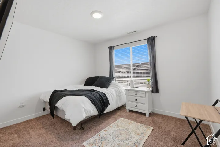 Bedroom featuring recessed lighting, a single window with blinds and drapes, and neutral-toned carpet flooring