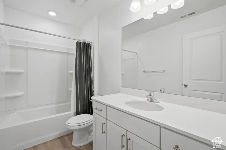 Bathroom featuring a white vanity with an integrated sink, a large wall-mounted mirror, and a tub/shower combination with white surround
