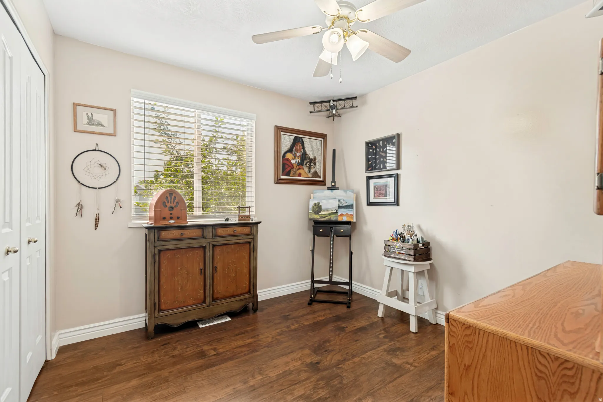 Room featuring wood-finish flooring, a window with blinds, and a ceiling fan