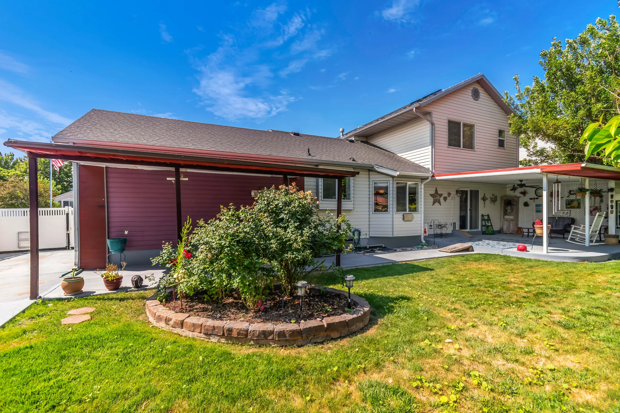 Expansive backyard with a manicured lawn, a large patio, and an extended covered area