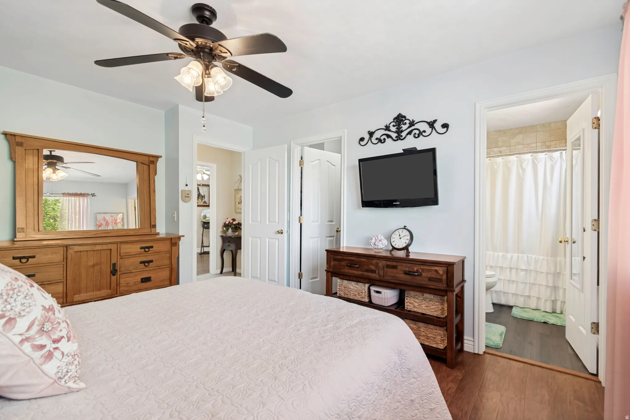 Room featuring wood-finish flooring, a ceiling fan with integrated lighting, and light-toned walls