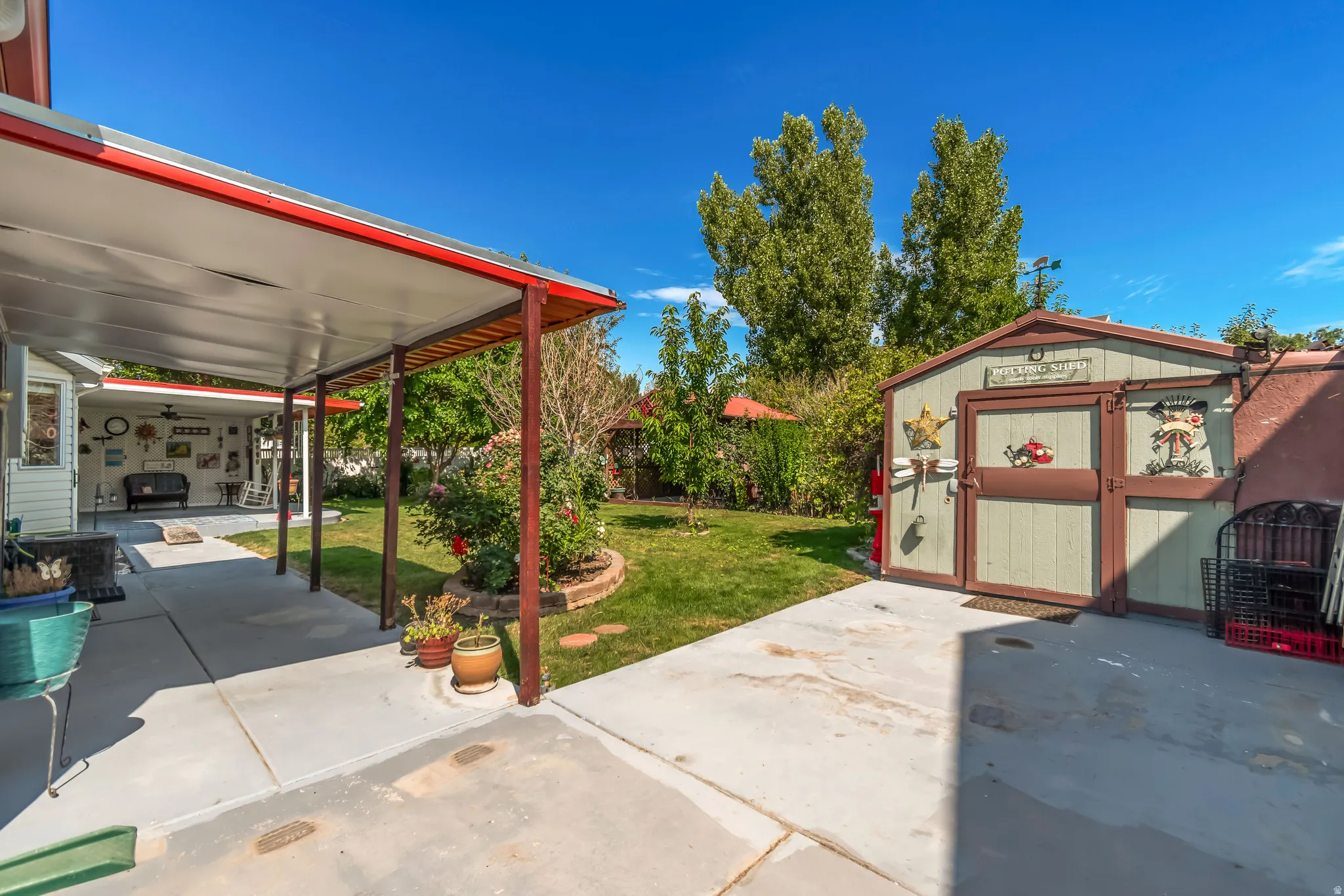 Expansive concrete patio area featuring an extended covered pergola