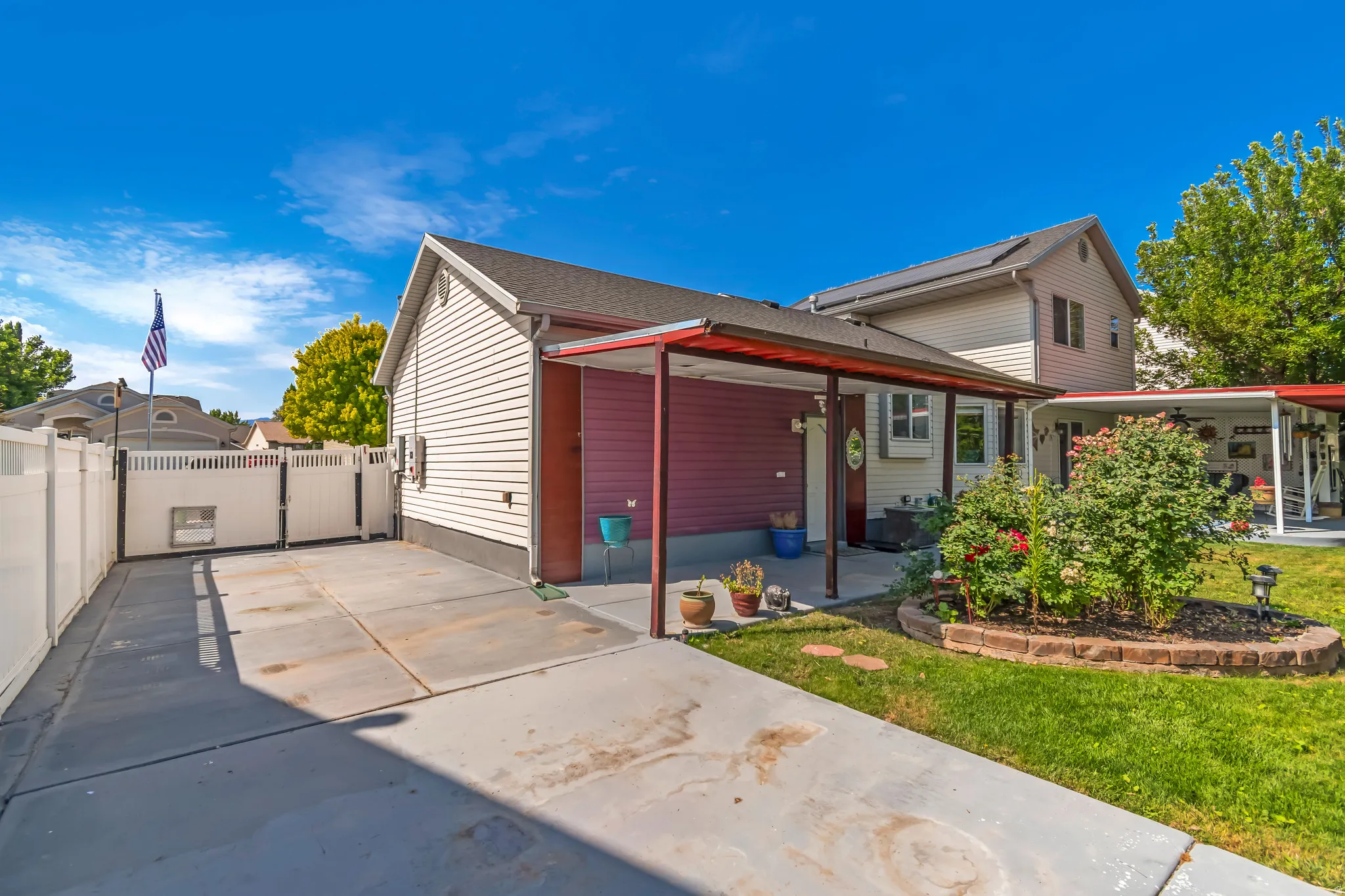 Concrete driveway with white vinyl fencing and double gate access