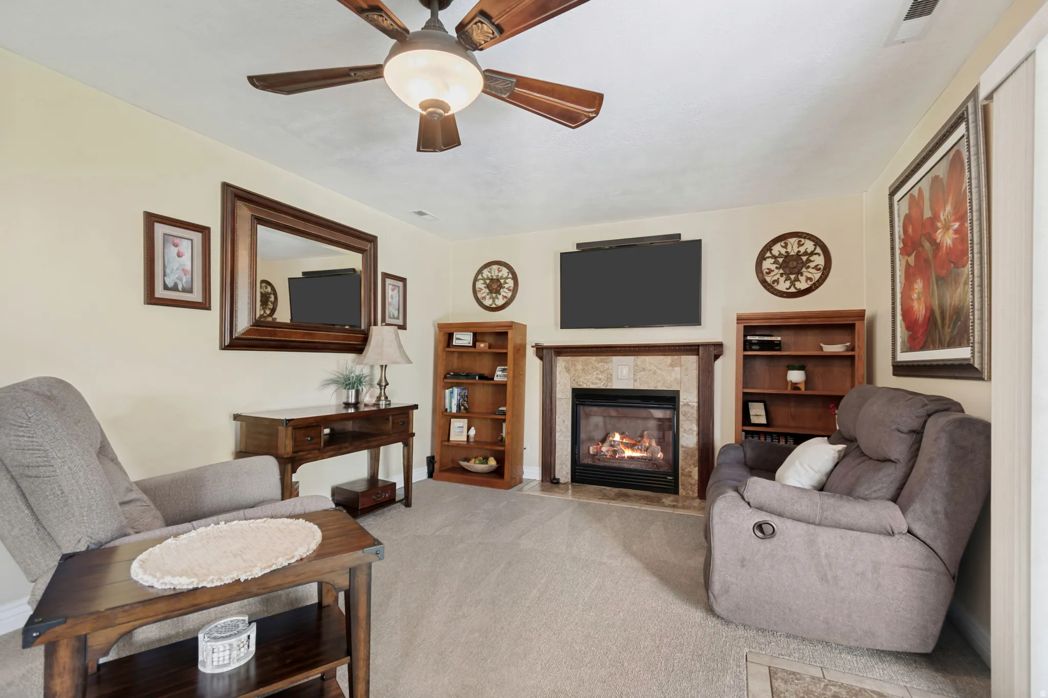 Living area featuring a gas fireplace with a tiled surround and wood mantel