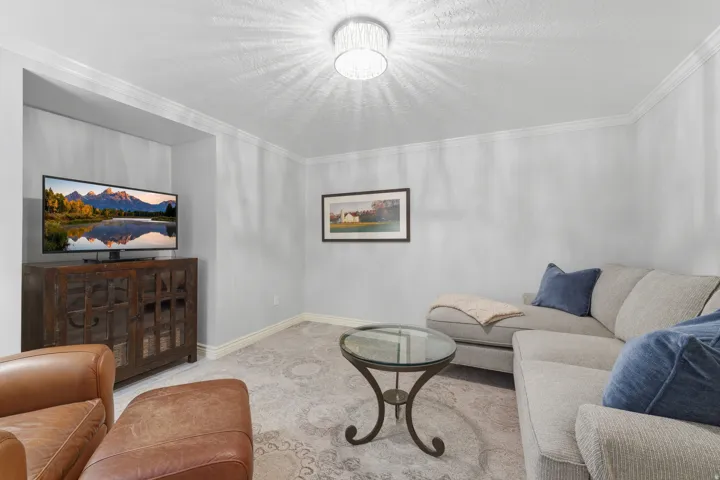 Recessed media niche with built-in overhead lighting, crown molding, and baseboards