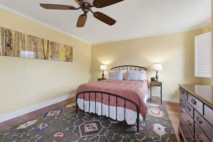Rich wood-finish flooring complemented by white baseboards and crown molding