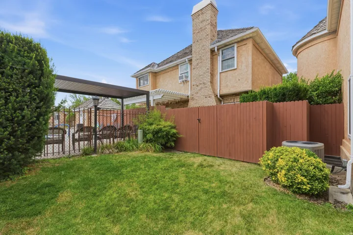 Private backyard featuring a manicured lawn, established landscaping, and a brown privacy fence