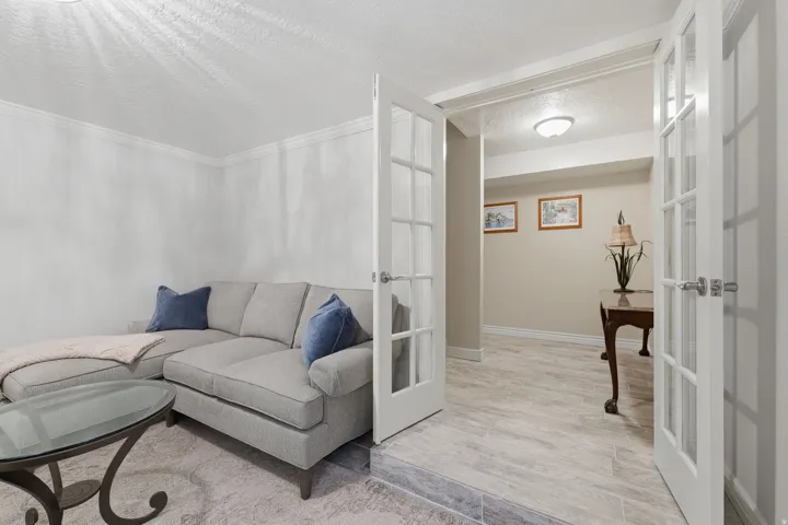 White French doors opening to an interior space with light-toned tile flooring
