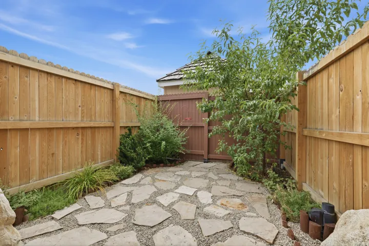Enclosed patio space featuring natural stone pavers and gravel