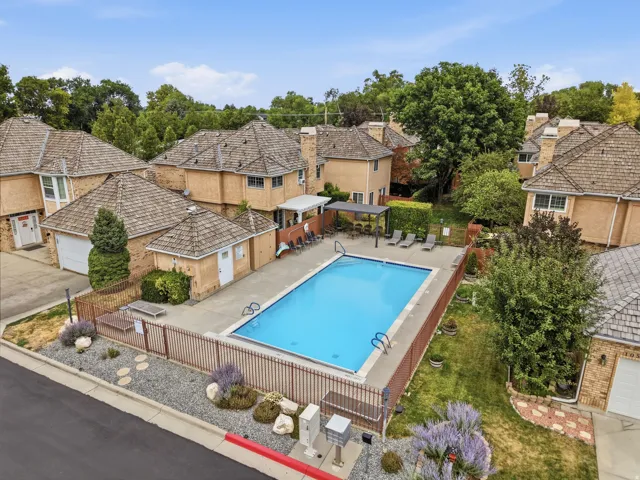 Rectangular swimming pool surrounded by a concrete deck and metal fencing