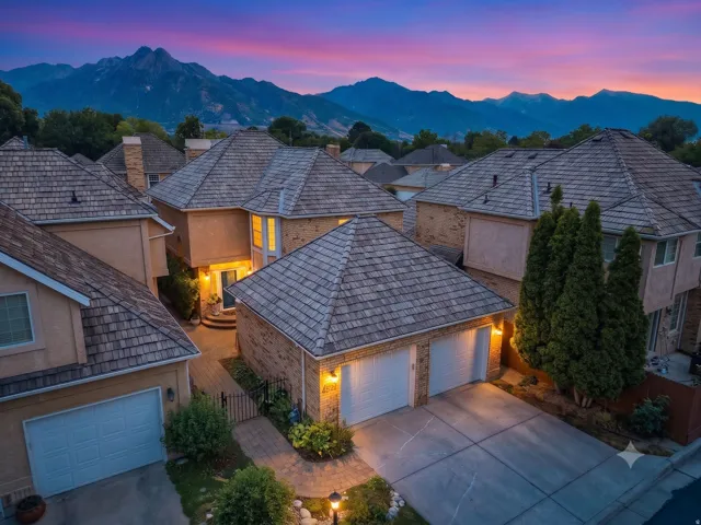 Stucco exterior with brick accents, multi-pane windows, and a two-car garage
