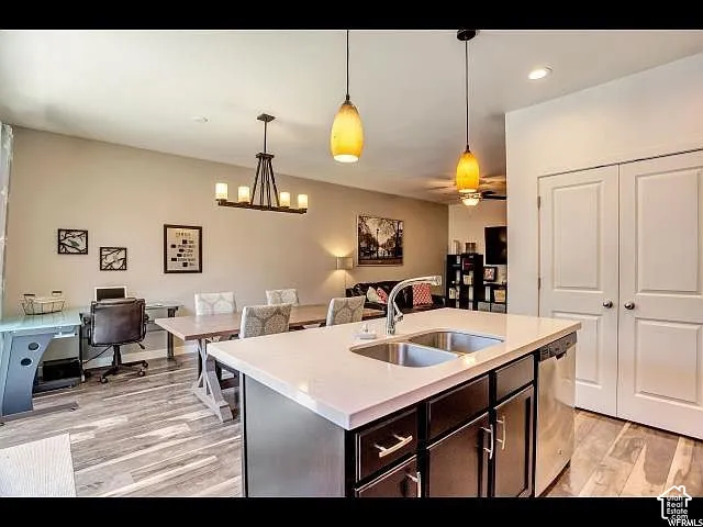 Kitchen island featuring a stainless steel sink, contemporary faucet, and integrated dishwasher