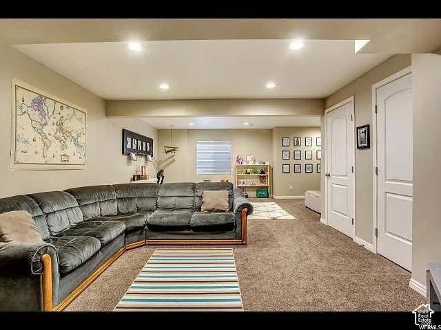 Spacious room featuring neutral carpeting, recessed lighting, and light beige wall paint