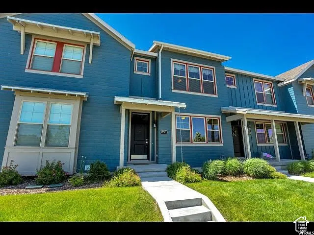 Contemporary townhouse exterior featuring blue siding with white trim accents and red window frames