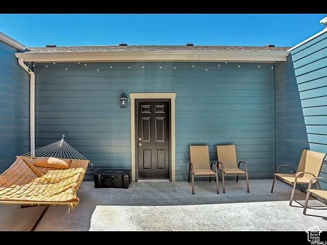 Exterior patio area featuring concrete flooring and blue horizontal siding