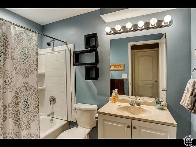 Bathroom vanity with an integrated sink and light-toned countertop, framed by a large mirror and six-bulb vanity lighting
