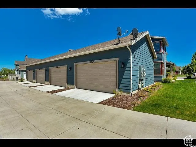 Multi-unit property featuring blue horizontal siding and individual garage doors