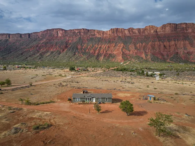 Single-story residence set on an expansive, undeveloped parcel featuring a prominent mountain range backdrop