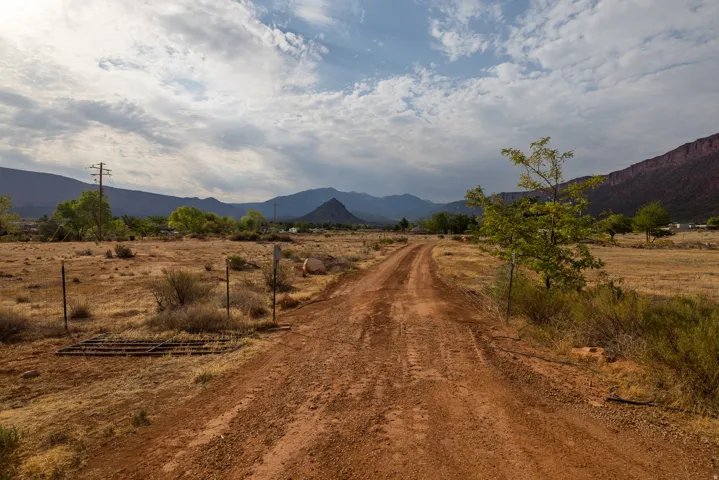 Expansive unpaved road traversing open terrain with distant mountains