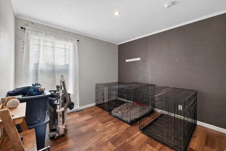 Room featuring wood-finish flooring, a window with blinds, and recessed lighting