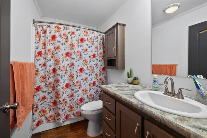 Bathroom featuring a vanity with a drop-in sink, brushed nickel faucet, and a patterned countertop