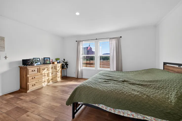 Spacious room featuring wood-finish flooring, white walls, and a recessed ceiling light