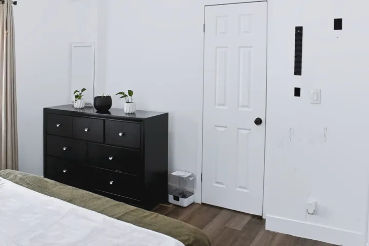 White paneled interior door with dark hardware, set against a light-colored wall with coordinating trim