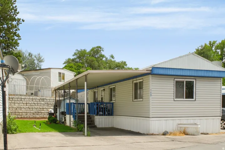 Manufactured home with light-colored siding and blue trim