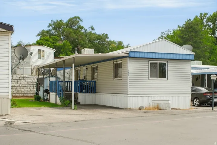 Single-story residence featuring light gray siding, white trim, and a blue accent fascia