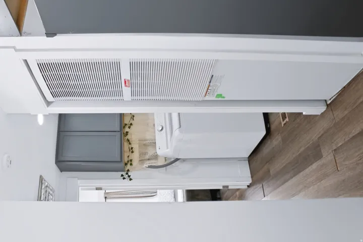 Dedicated utility area featuring a white washing machine, matching dryer, and wood-finish flooring