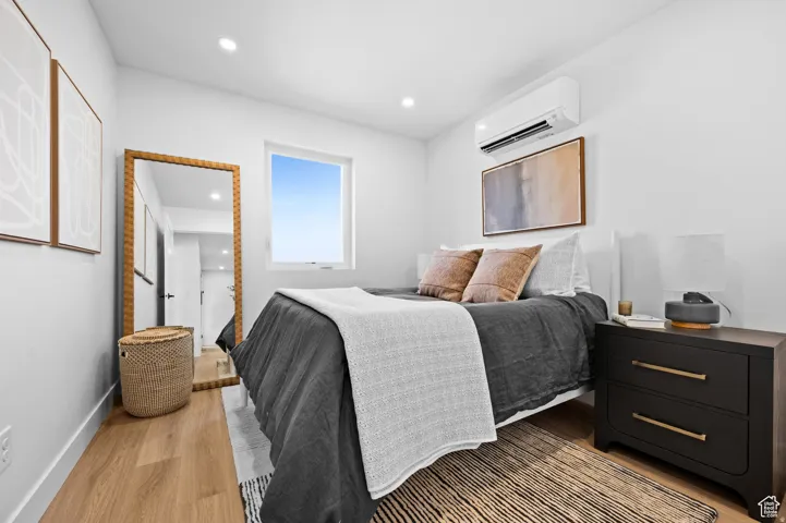 Bright room featuring a window, recessed lighting, and wood-finish flooring