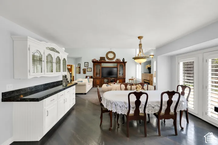 Dining area with dark wood-finish flooring and a decorative chandelier