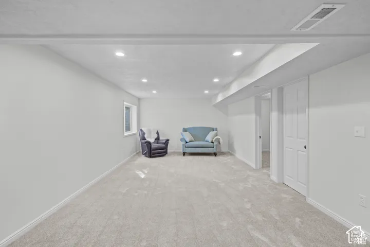 Carpeted recreational room with recessed lighting and a window