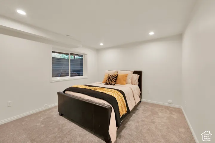 Carpeted room featuring a white-framed window, recessed lighting, and crisp white walls
