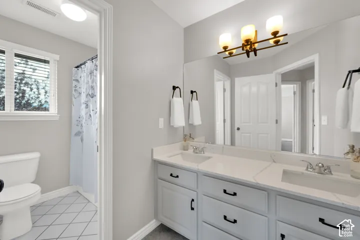 Double vanity with light gray cabinetry, integrated sinks, and polished chrome faucets