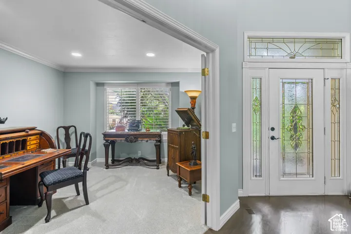 Entryway featuring a white door with decorative glass inserts, flanking sidelights, and an overhead transom window