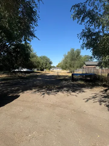 Expansive land parcel featuring existing perimeter fencing and mature trees