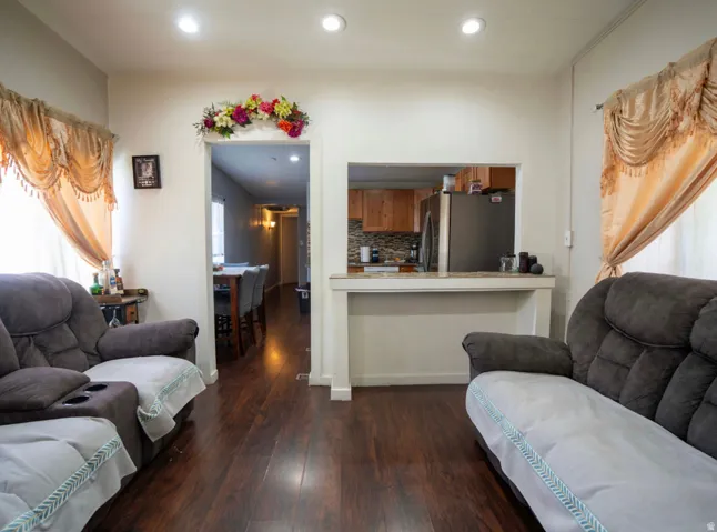 Living area featuring recessed lighting, wood-finish flooring, and a pass-through window to the kitchen