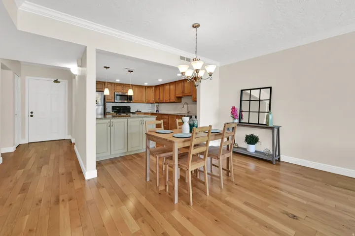 Open-concept dining and kitchen area featuring wood-finish flooring throughout
