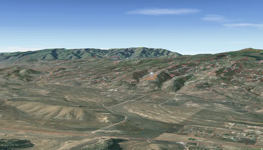Expansive aerial perspective showcasing a mountainous terrain with varied elevations and distant clear skies