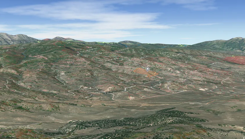 Expansive mountain landscape featuring varied terrain and scattered vegetation