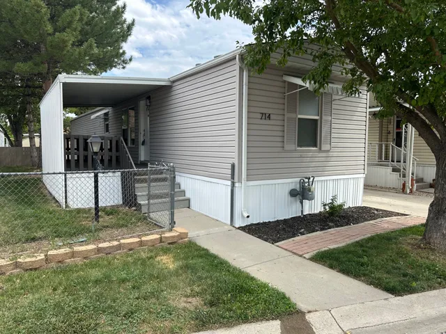 Manufactured home featuring light gray horizontal siding and white skirting