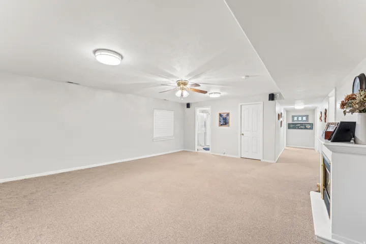 Expansive room featuring light-toned carpet flooring, a ceiling fan, and recessed lighting fixtures