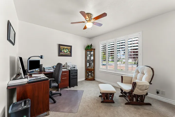 Room featuring light-colored walls, carpeted flooring, and a ceiling fan with integrated lighting