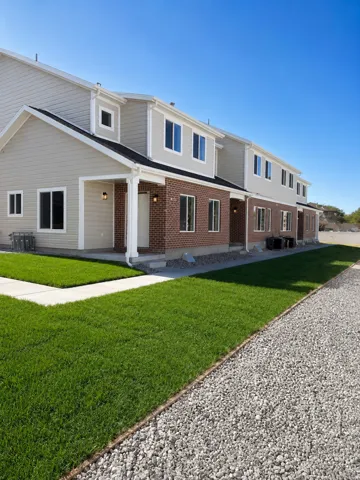Contemporary townhome exterior featuring brick and light-toned siding