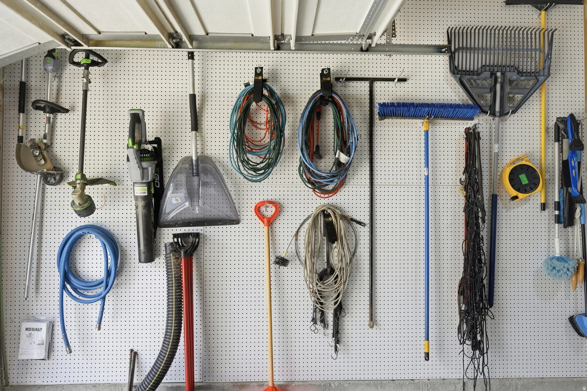 Garage interior featuring white pegboard wall storage