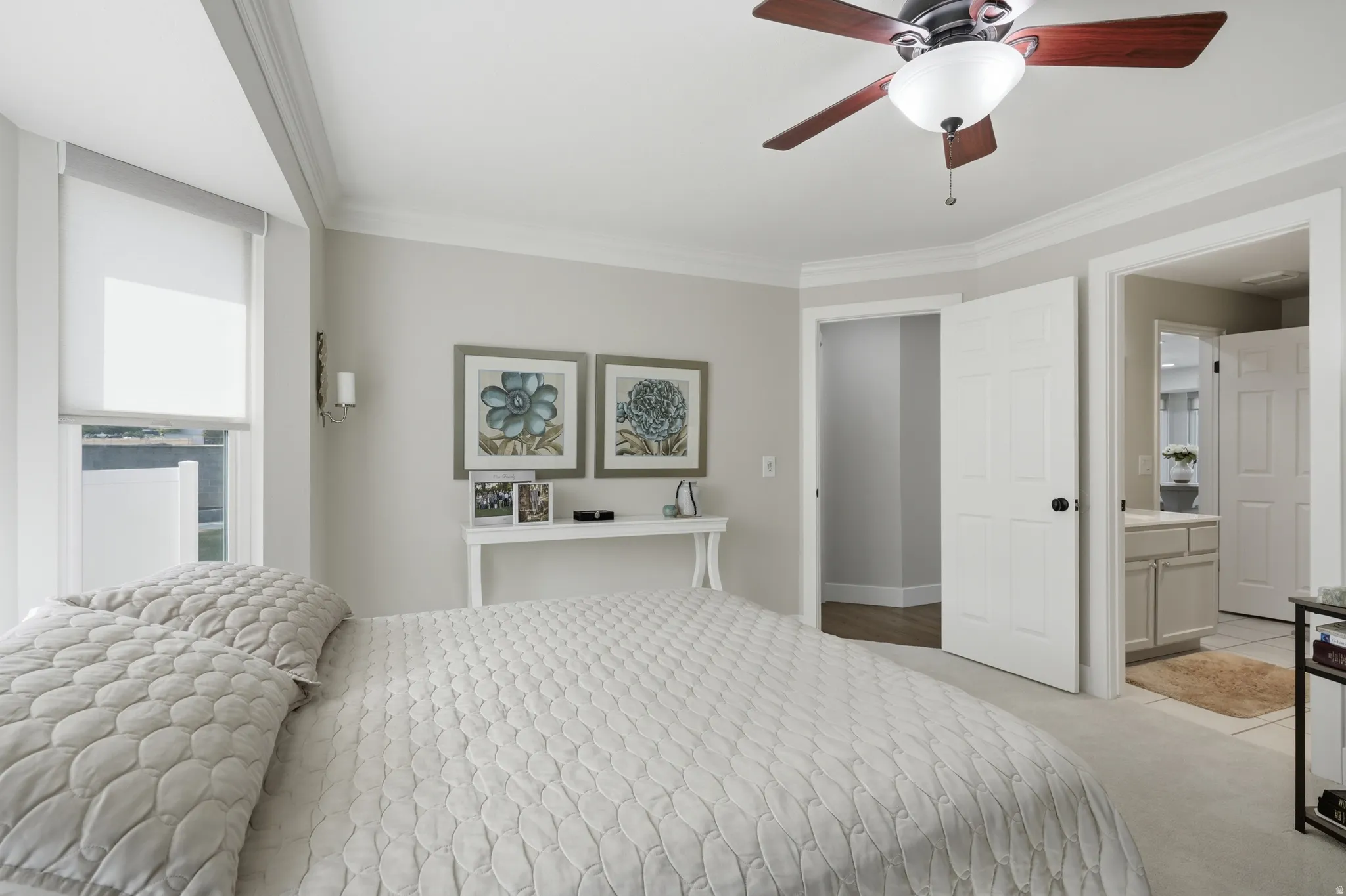 Bedroom featuring neutral wall colors, crown molding, and a ceiling fan with integrated lighting