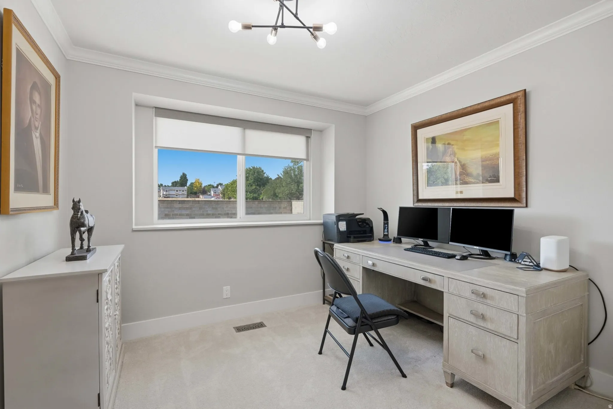 Well-lit room featuring light-colored walls, crown molding, and carpeted flooring