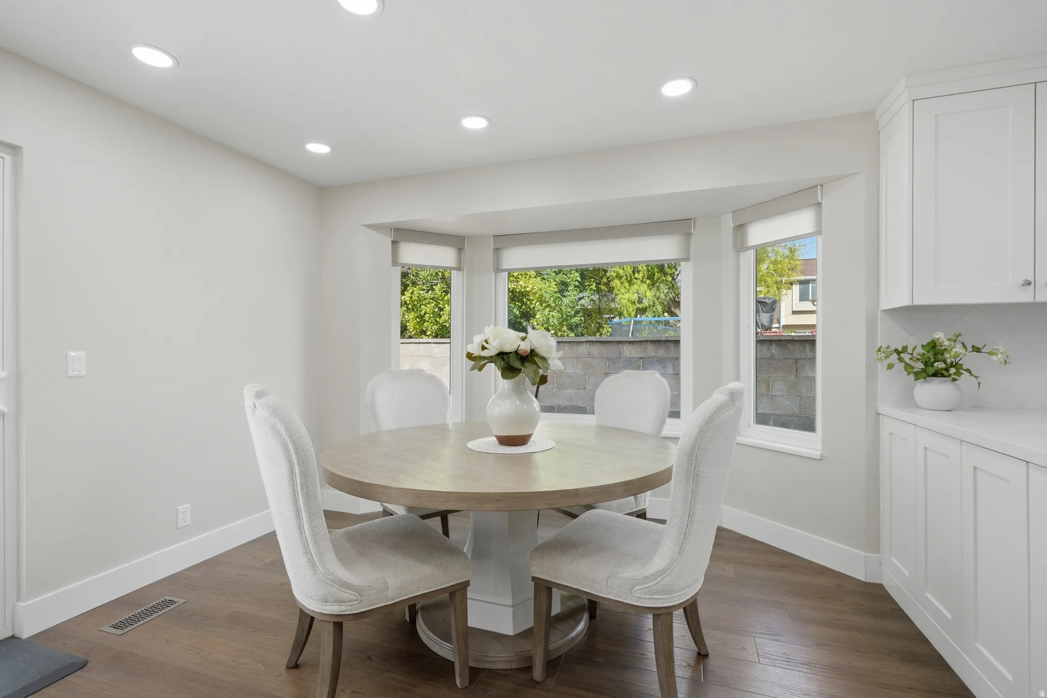 Dining area featuring a bay window, recessed lighting, wood-finish flooring, and built-in cabinetry with a countertop